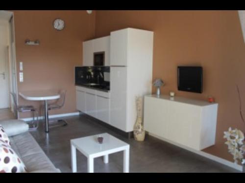 ein Wohnzimmer mit einem Sofa und einem Tisch in der Unterkunft Coquet studio classé trois étoiles in Balaruc-les-Bains