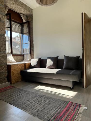 a couch in a living room with a window at Casa Valverde I in Amarante