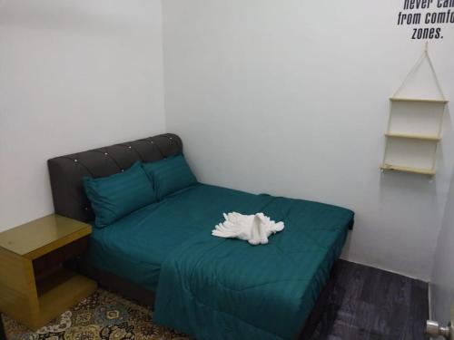 a green bed with a stuffed animal on top of it at Homestay Embah Ros & Embah Lek in Hutan Melintang