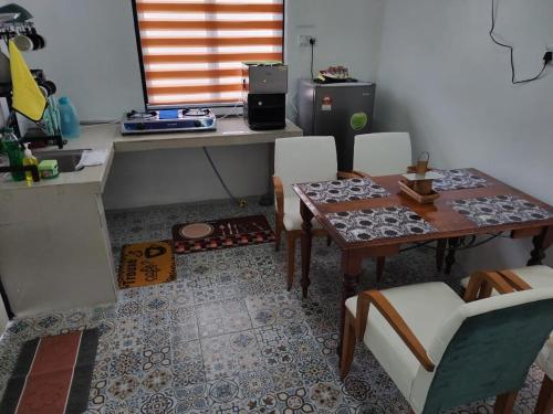 a kitchen with a table and a table and chairs at Homestay Embah Ros & Embah Lek in Hutan Melintang