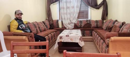 Ein Mann auf einer Couch im Wohnzimmer in der Unterkunft dalas in Saidia 