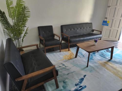 a living room with two chairs and a coffee table at Homestay Embah Ros & Embah Lek in Hutan Melintang