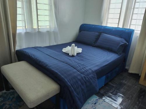 a blue bed with a stuffed animal on it at Homestay Embah Ros & Embah Lek in Hutan Melintang