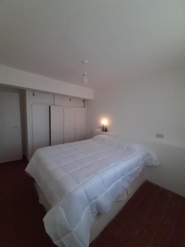1 cama blanca grande en una habitación blanca en Blue Wind en Comodoro Rivadavia