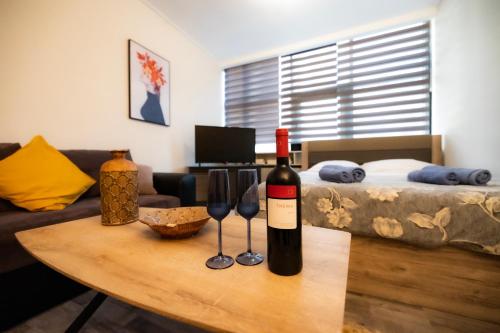 a bottle of wine and two wine glasses on a table at κέντρο πόλης Βασίλης in Ioannina