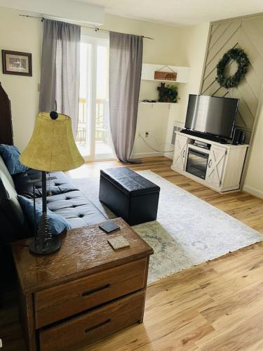 a living room with a couch and a table with a lamp at Sugar Mountain Mile High Cozy Condo! in Sugar Mountain