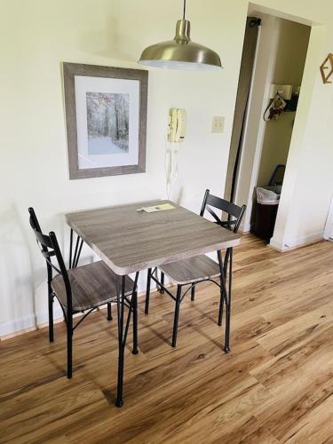 a table and chairs in a room with a wooden floor at Sugar Mountain Mile High Cozy Condo! in Sugar Mountain