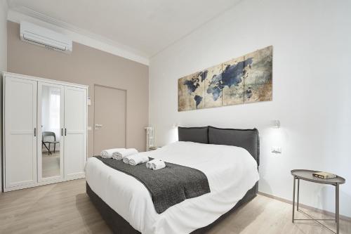 a white bedroom with a large bed and a chair at Casa Flaminia in Rome