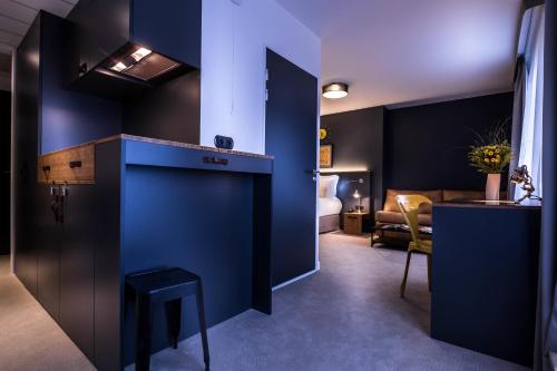 a hotel room with blue walls and a bed at Best Western Plus Suitcase Paris La Défense in Bois-Colombes