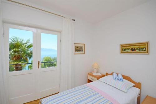 a bedroom with a bed and a sliding glass door at Lui in Gradac
