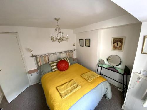 um quarto com uma cama grande e um cobertor amarelo em Seaside Flat With Sunny Garden. em Brighton & Hove