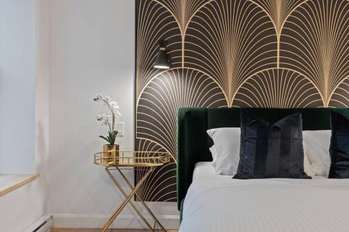 a bedroom with a bed with a gold and black headboard at Initial / Art-déco / Quebec in Quebec City