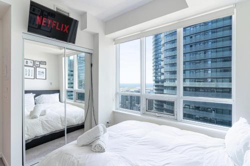 a bedroom with two beds and a large window at Beautiful Modern Toronto Luxurious Scotiabank Arena in Toronto