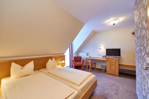フロンハイムにあるLandhotel im Klostereck Strubel-Roosのベッドと机があるホテルの部屋