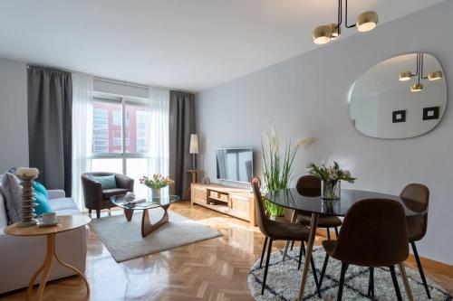 salon ze stołem jadalnym i krzesłami w obiekcie Vivienda con zona de trabajo, piscina y parking w Madrycie