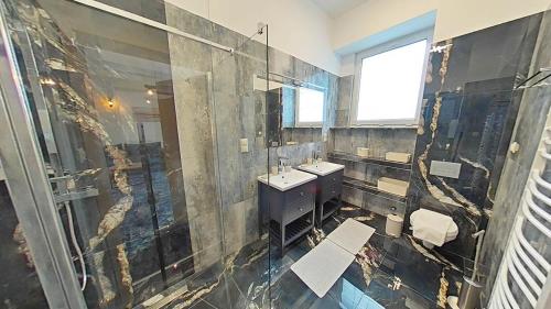 duża łazienka z umywalką i prysznicem w obiekcie Apartament ARKA w mieście Jarosławiec