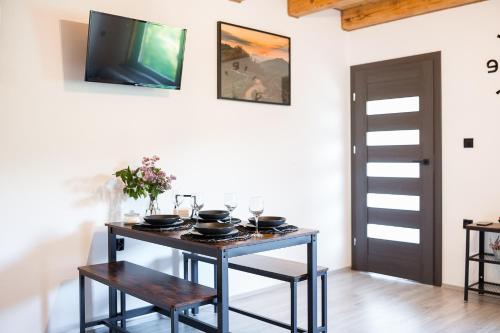a dining room with a table and a tv on the wall at Antkowe Wzgórze in Polańczyk