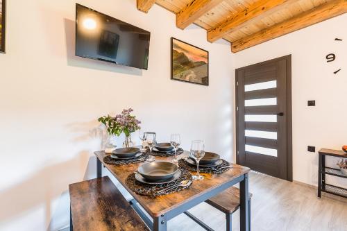 a dining room with a table with plates and glasses at Antkowe Wzgórze in Polańczyk