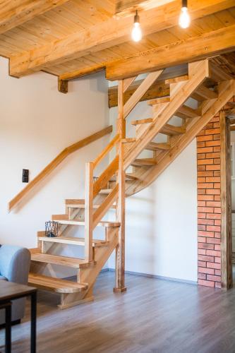 a wooden staircase in a loft with a table at Antkowe Wzgórze in Polańczyk