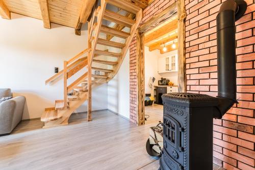 a living room with a brick wall and a wood stove at Antkowe Wzgórze in Polańczyk