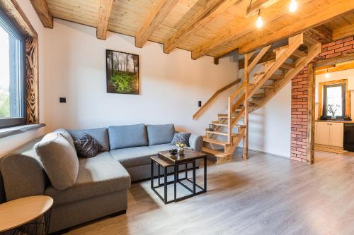 a living room with a couch and a staircase at Antkowe Wzgórze in Polańczyk