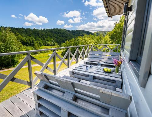a wooden deck with a table and chairs on a balcony at Antkowe Wzgórze in Polańczyk
