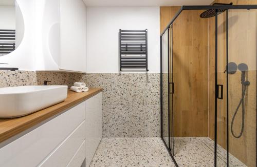 un baño con lavabo y ducha en Apartamenty KTW, en Katowice