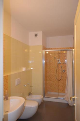 a bathroom with two sinks and a shower and two toilets at Casa per ferie religiosa Figlie di Nazareth in Pisa