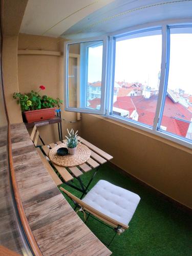a room with a table and chairs and windows at Sunset Yavorov Pomorie in Pomorie
