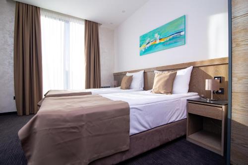 een hotelkamer met een groot bed en een raam bij Alibi Zlatibor Inn in Zlatibor