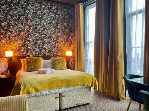 a bedroom with a bed with a yellow blanket at LuXe Apartments Kemptown in Brighton & Hove