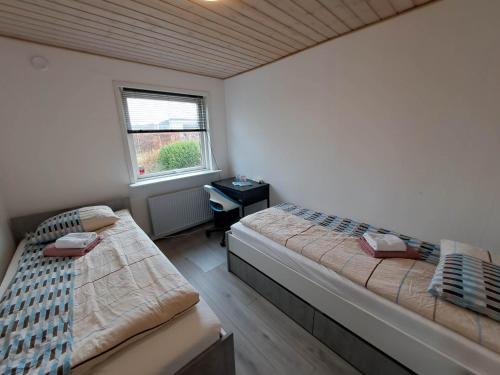 een slaapkamer met 2 bedden en een bureau. bij Accomodation at Jasmin house in Rødby