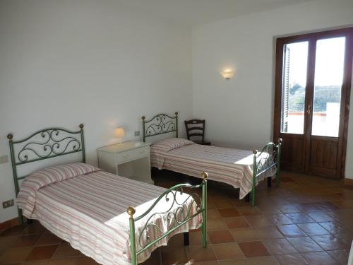 2 Betten in einem Zimmer mit Fenster in der Unterkunft Azienda Il Tizzano in Albinia