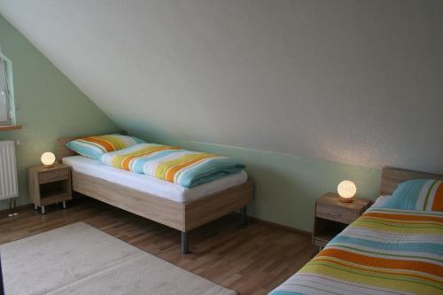 - une chambre avec 2 lits et 2 lampes sur les tables dans l'établissement Ferienhaus Helbig Buckow, à Buckow