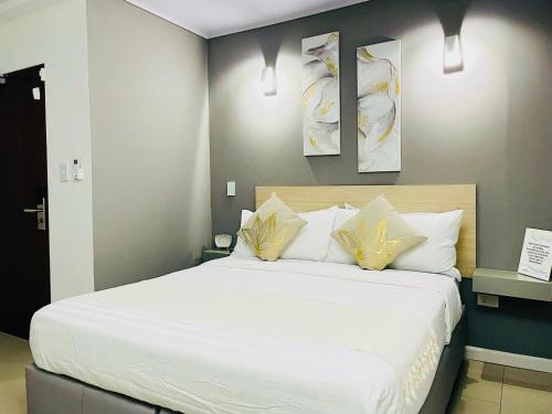 1 dormitorio con 1 cama con sábanas blancas y almohadas amarillas en DiHouse Apartment - Habitacion Privada, en San Andrés