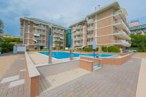 an apartment complex with a swimming pool and two buildings at Residence Puerto Del Sol Immobiliare Pacella in Lido di Jesolo