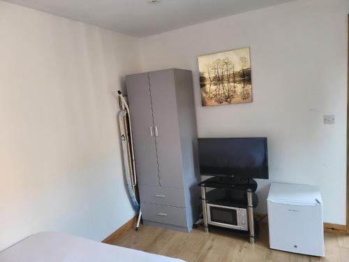 a bedroom with a large gray cabinet and a television at Midway in Garston