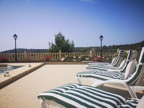 a row of lounge chairs sitting next to a swimming pool at Suites in Ca Olivar, Moraira in Teulada