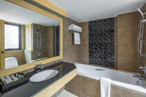 a bathroom with a tub and a sink and a mirror at Nora LakeView in Chaweng