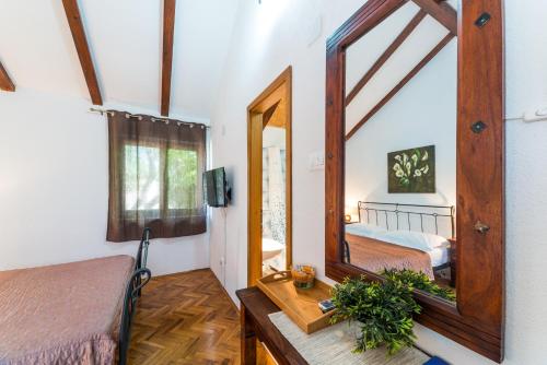 a room with two beds and a mirror at Apartmani Bugenvilija in Brbinj
