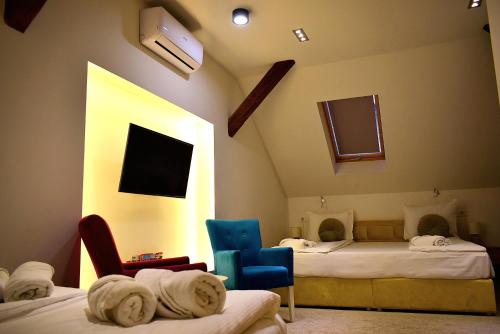 pokój z 2 łóżkami i 2 krzesłami w obiekcie Deluxe Nortel Hotel w Sarajewie