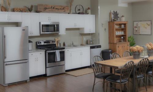 a kitchen with white appliances and a table with chairs at The Green Heart Inn in Kingsville