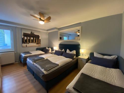 een slaapkamer met 2 bedden en een plafondventilator bij City Holiday Apartments Berlin in Berlijn