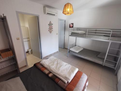a room with two bunk beds and a lamp at Villa Cosy de plain pied - Marseillan in Marseillan