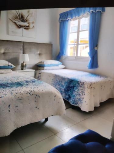 2 Betten in einem Zimmer mit Fenster in der Unterkunft Pendhous Sabina mit Jacuzzi in Callao Salvaje
