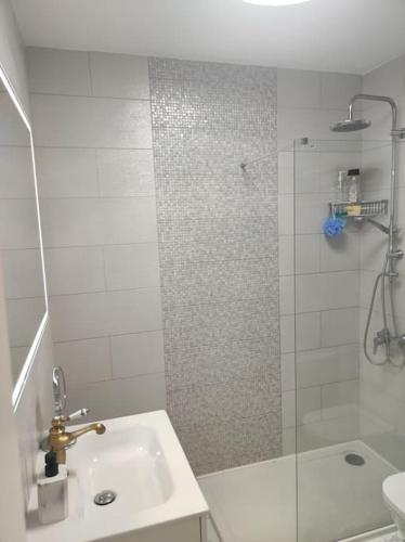 a white bathroom with a shower and a sink at Pendhous Sabina mit Jacuzzi in Callao Salvaje