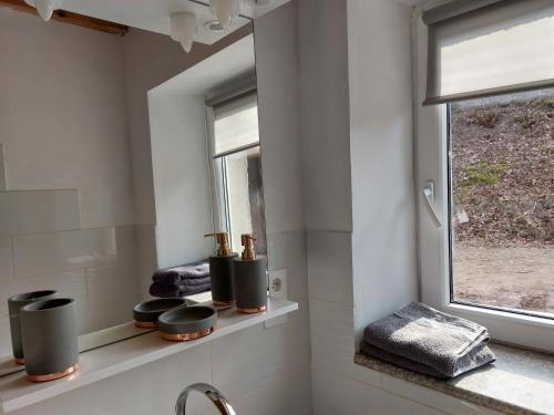 a white bathroom with a window and a sink at Gite de Moulin Maurt 1 in Xertigny