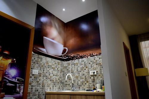 a kitchen with a sink and a painting on the wall at Deluxe Nortel Hotel in Sarajevo