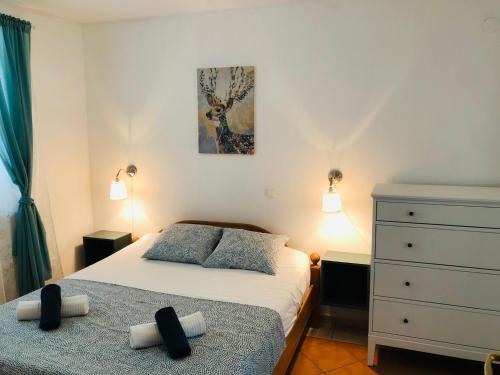 ein Schlafzimmer mit einem Bett und einer Kommode in der Unterkunft Green Paradise Apartment Novalja in Novalja