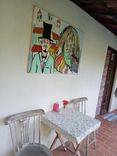 ポルト・デ・ガリーニャスにあるExclusive Guest Houseのテーブルと椅子2脚、壁画